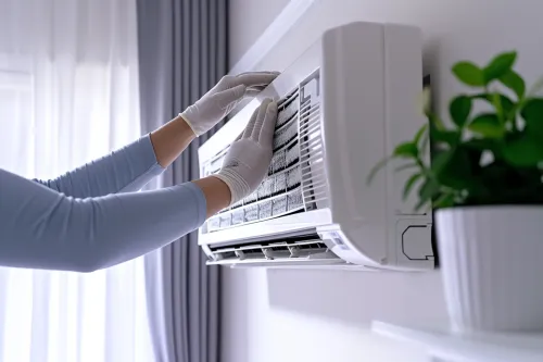 Nettoyage d'un filtre de climatiseur encrassé avec brosse et solution désinfectante, étapes claires pour un entretien efficace